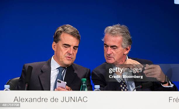 Alexandre de Juniac, chief executive officer of Air France-KLM Group, left, holds a smartphone as he sits beside Frederic Gagey, chief executive...