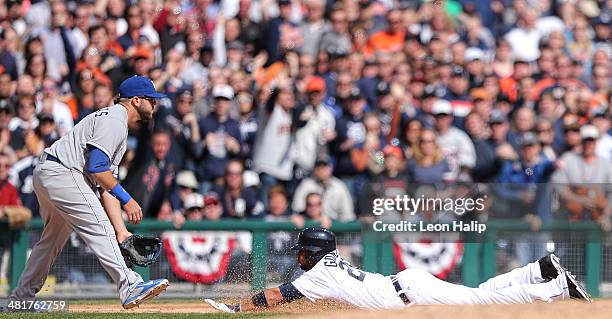 Alex Gonzalez of the Detroit Tigers slides into third base after hitting a triple to center field in the seventh inning scoring Alex Avila during the...