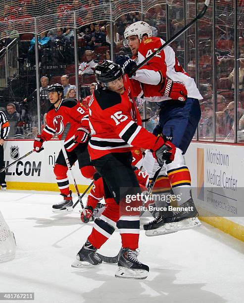 Tuomo Ruutu of the New Jersey Devils checks Quinton Howden of the Florida Panthers during the first period at the Prudential Center on March 31, 2014...