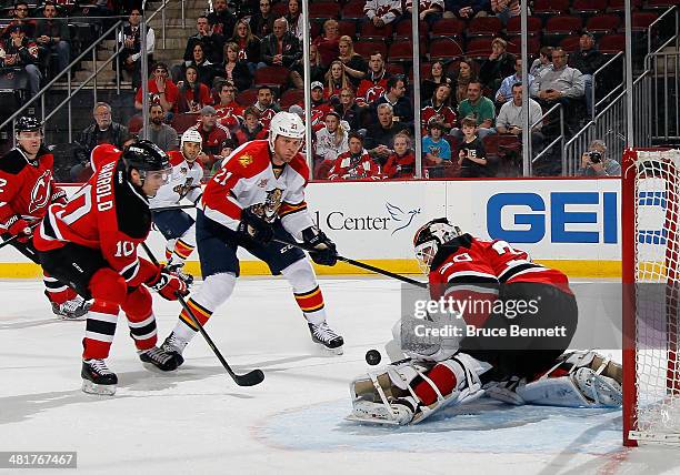 Martin Brodeur of the New Jersey Devils makes the first period save as Krys Barch of the Florida Panthers looks for the rebound at the Prudential...