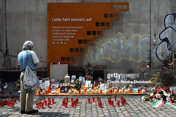 Man looks at candles and flowers left by mourners at the makeshift memorial to victims of the Love Parade disaster on its fifth anniversary on July...