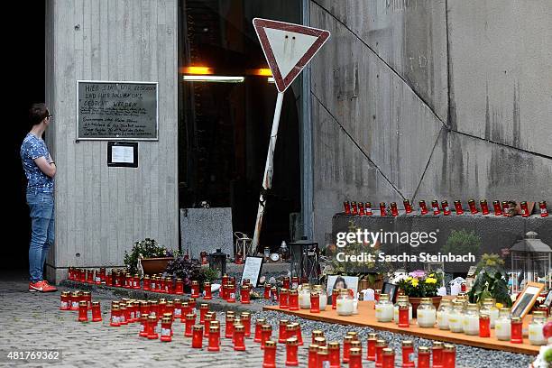 Man looks at candles and flowers left by mourners at the makeshift memorial to victims of the Love Parade disaster on its fifth anniversary on July...