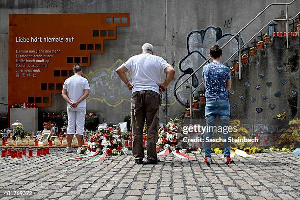 People look at candles and flowers left by mourners at the makeshift memorial to victims of the Love Parade disaster on its fifth anniversary on July...