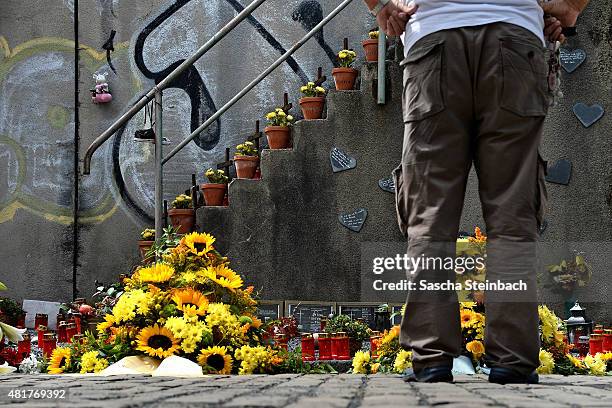 Man looks at candles and flowers left by mourners at the makeshift memorial to victims of the Love Parade disaster on its fifth anniversary on July...