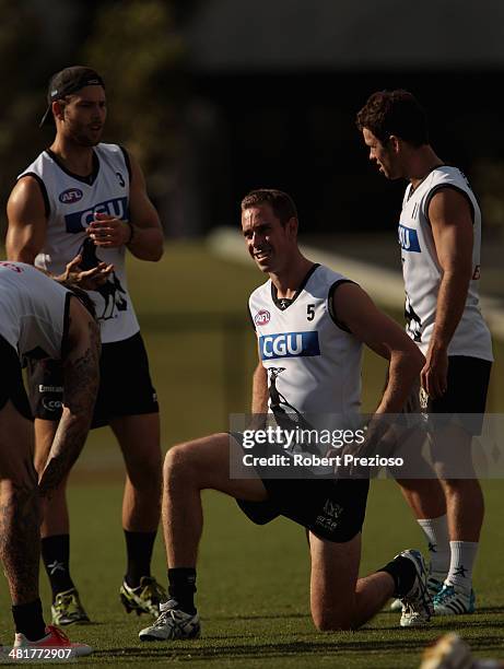 Nick Maxwell stretches with team-mates during a Collingwond Magpies AFL training session at Olympic Park on April 1, 2014 in Melbourne, Australia.