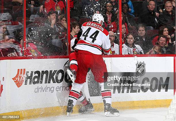 Jay Harrison of the Carolina Hurricanes slams Jean-Gabriel Pageau of the Ottawa Senators against the glass at Canadian Tire Centre on March 31, 2014...