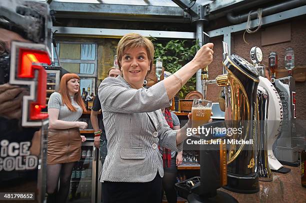 First Minister Nicola Sturgeon pulls a pint of lager as she joins invited guests attend the reopening of the Clutha Bar on July 24, 2015 in Glasgow,...