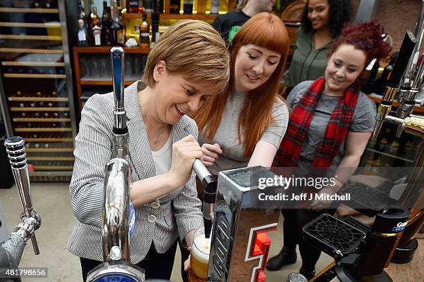 First Minister Nicola Sturgeon pulls a pint of lager as she joins invited guests attend the reopening of the Clutha Bar on July 24, 2015 in Glasgow,...