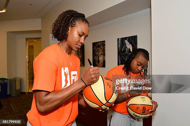 Tamika Catchings of the Indiana Fever and Riquna Williams of the Tulsa Shock sign autographs during a WNBA Fit All-Star Clinic presented by Kaiser...