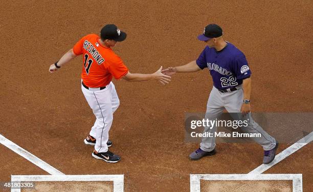 Head coach Mike Redmond of the Miami Marlins and head coach Walt Weiss of the Colorado Rockies shake hands during Opening Day at Marlins Park on...