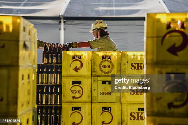 An employee puts empty beer bottles in bins at the Ambev SA bottling facility in Lages, Brazil, on Friday, July 17, 2015. Ambev SA is scheduled to...