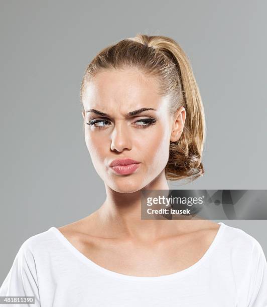 headshot of disappointed blond hair young woman - suspicion stock pictures, royalty-free photos & images