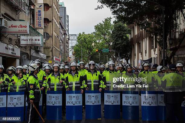 Riot police stand guard outside the legislature as government supporters rally aiming to "get back" the legislature which is currently occupied by...