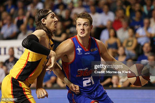 Daniel Johnson of the 36ers drives against Auryn MacMillan of the Tigers during game three of the NBL Semi Final series between the Adelaide 36ers...