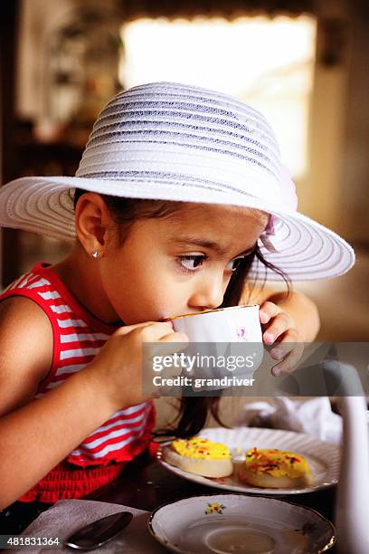 beautiful hispanic african american girl having a tea party - cupcake teacup stockfoto's en -beelden