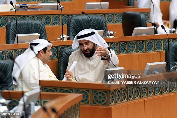 Kuwaiti oil minister Ali al-Omair talks with MP Yaqoub al-Sanea during a parliament session at Kuwait's National Assembly on April 1, 2014 in Kuwait...