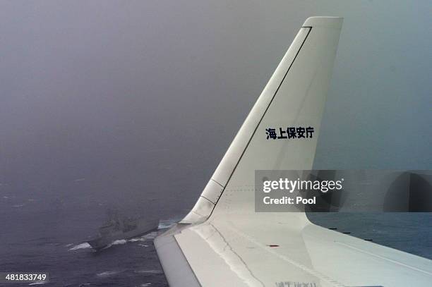 Japan Coast Guard Gulfstream aircraft flies past HMAS Toowoomba as they conduct searches for wreckage and debris of missing Malaysia Airlines Flight...