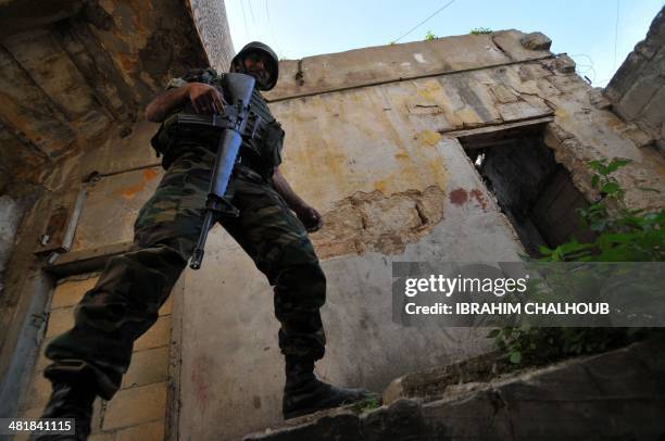 Soldier of the Lebanese armed forces holds a weapon as he patrols the neighbouring district of Bab el-Tebbaneh in the northern port city of Tripoli,...