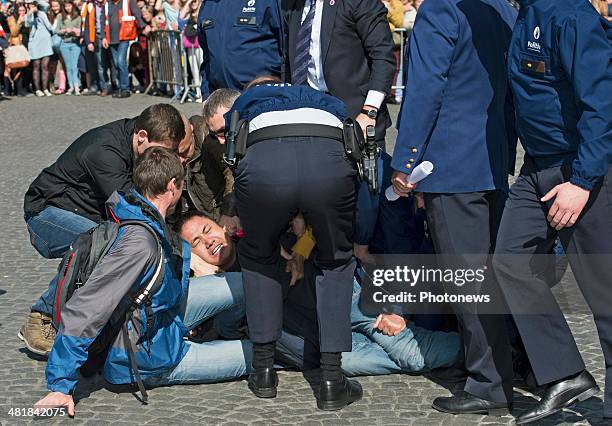 Protester is restrained by police outside the front of the city hall, during an official visit by Chinese President Xi Jinping and First Lady Xi-Peng...