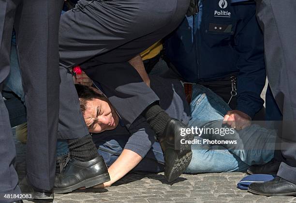 Protester is restrained by police outside the front of the city hall, during an official visit by Chinese President Xi Jinping and First Lady Xi-Peng...