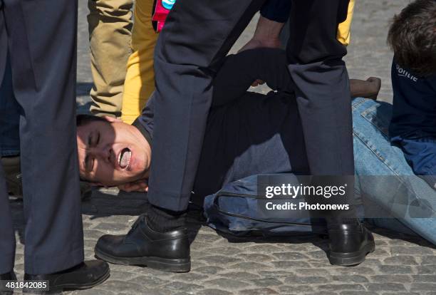 Protester is restrained by police outside the front of the city hall, during an official visit by Chinese President Xi Jinping and First Lady Xi-Peng...