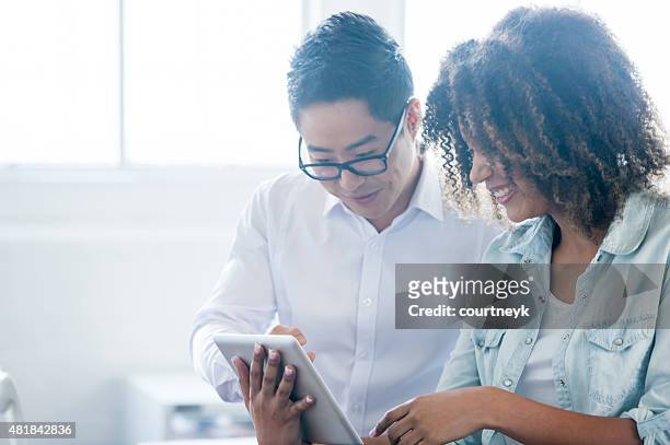 business man and woman working on digital tablet. - touchpad bildbanksfoton och bilder