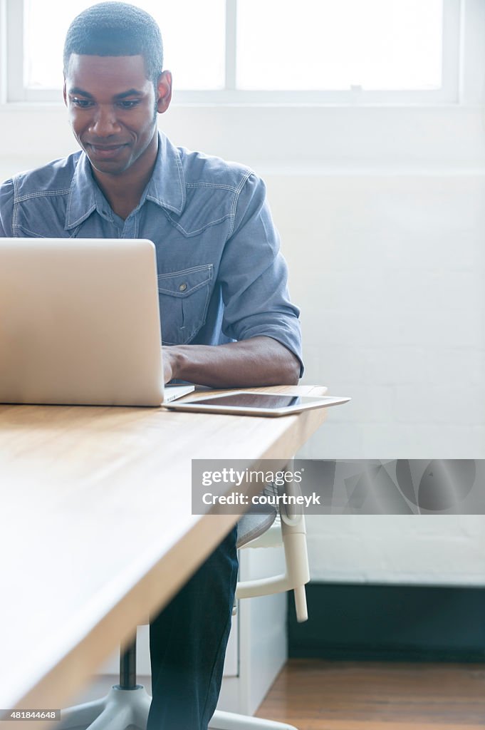 Afroamerikanischer Mann arbeitet auf einem laptop-computer.