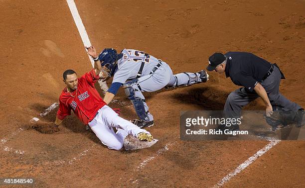 Mookie Betts of the Boston Red Sox slides as he avoids the tag by Alex Avila of the Detroit Tigers at home plate as he scored the winning run during...