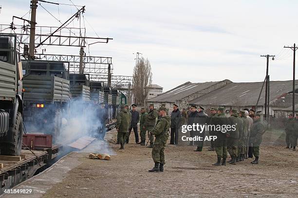 Russian soldiers unload trainload of KAMAZ military trucks after their arrival at Ostryakovo railway station, some 20 km outside near the Crimean...