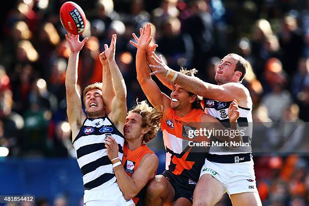 Cory Gregson and Josh Walker of the Cats contest posession with Nic Hayes and Callan Ward of the Giants during the round 17 AFL match between the...