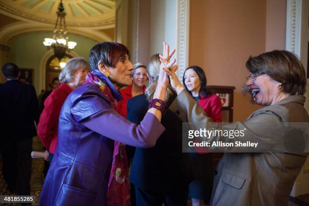 Rep. Rosa DeLauro , L, high fives U.S. Sen. Amy Klobuchar before a press conference to urge Congress to pass the Paycheck Fairness Act, on Capitol...