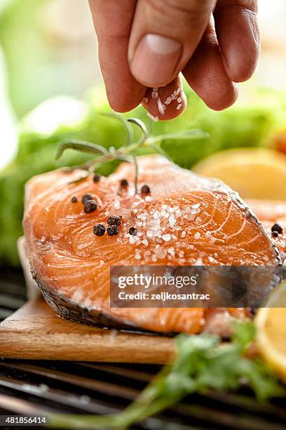 seasoning the meat - forel stockfoto's en -beelden