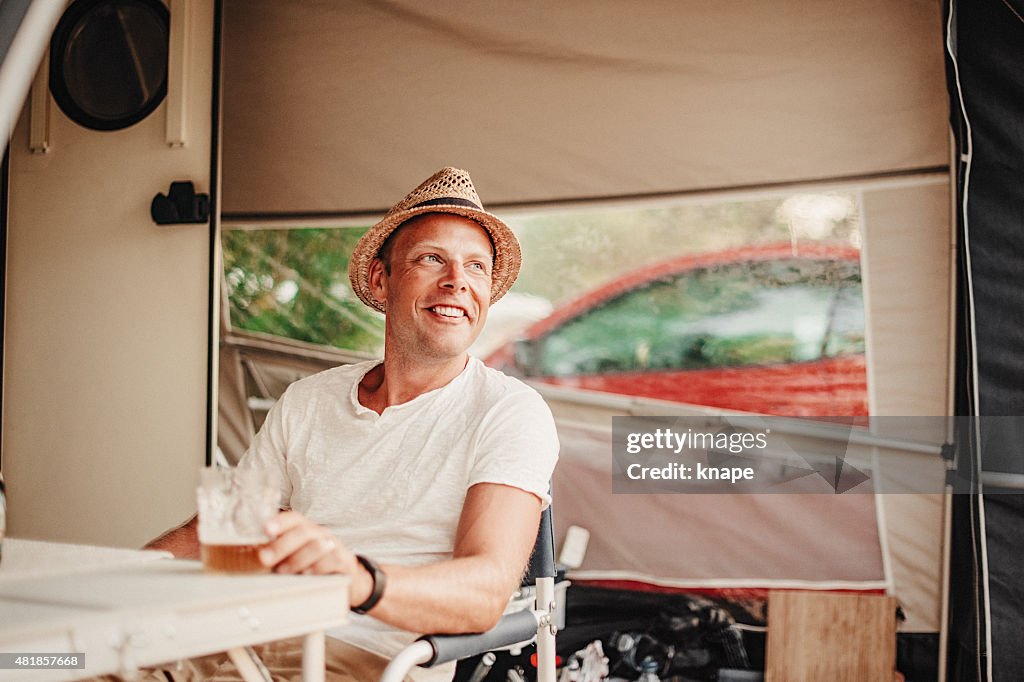 Man camping in his caravan at camping