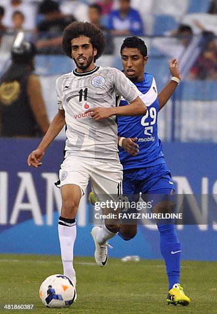 Qatar's Al-Sadd player Hassan Khalid Al-Haidos fights for the ball against Saudi's Al-Hilal player Salem Al-Dawsari during their AFC Champions League...