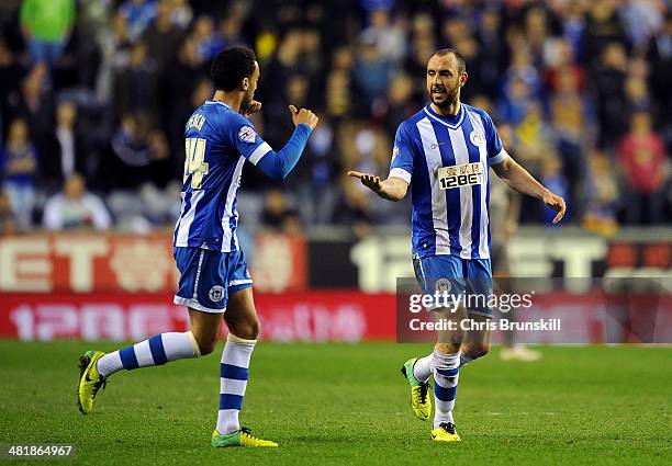 Ivan Ramis of Wigan Athletic is congratulated by team-mate James Perch after scoring the opening goal during the Sky Bet Championship match between...