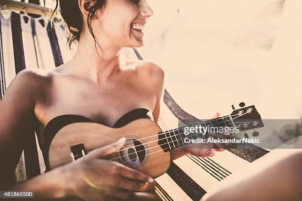 lächelnd musiker in der hängematte - ukulele stock-fotos und bilder