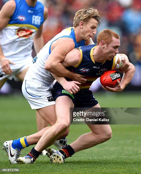 Tom Lynch of the Crows tries to evade a tackle during the round 17 AFL match between the Adelaide Crows and the GOld COast Titans at Adelaide Oval on...