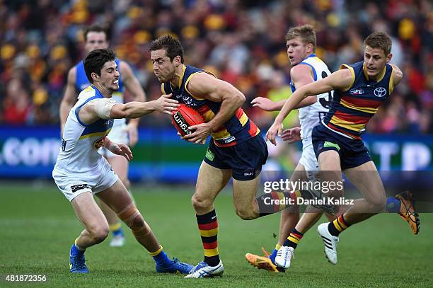 Richard Douglas of the Crows evades a tackle during the round 17 AFL match between the Adelaide Crows and the GOld COast Titans at Adelaide Oval on...