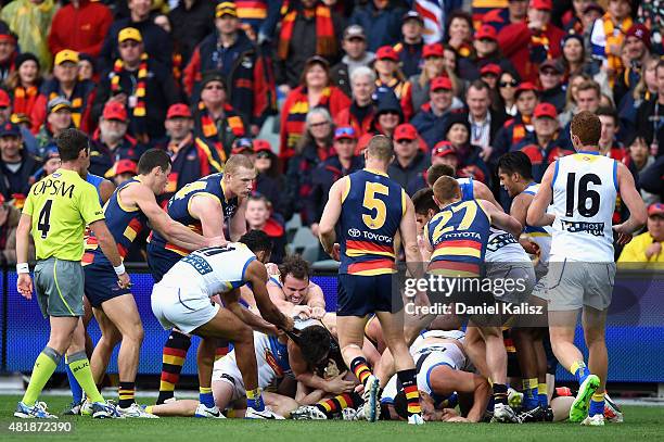 Players wrestle during the round 17 AFL match between the Adelaide Crows and the GOld COast Titans at Adelaide Oval on July 25, 2015 in Adelaide,...