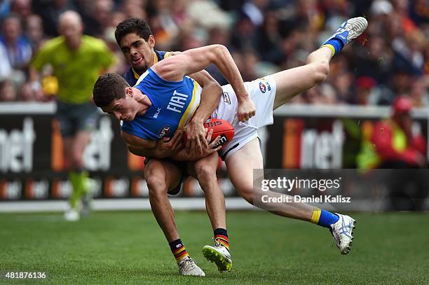 Andrew Raines of the Suns is tackled by Charlie Cameron of the Crows during the round 17 AFL match between the Adelaide Crows and the GOld COast...