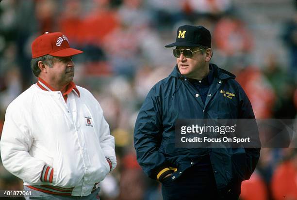 Head Coach Bo Schembechler of the Michigan Wolverines talks with Head Coach Earle Bruce of the Ohio State Buckeyes prior to the start of an NCAA...