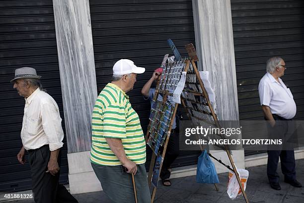 People walk past a lottery-tickets stall in Athens on July 25, 2015. Debt-crippled Greece on July 24 took a step closer to a huge third international...