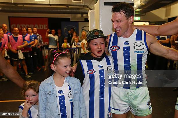 Brent Harvey of the Kangaroos sings the team song with his children after his 400th game during the round 17 AFL match between the Brisbane Lions and...