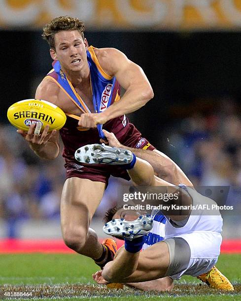 Jack Redden of the Lions attempts to break free from the defence of Brent Harvey of the Kangaroos during the round 17 AFL match between the Brisbane...