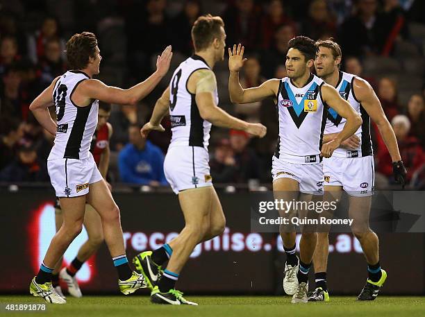 Chad Wingard of the Power is congratulated by team mates after kicking a goal during the round 17 AFL match between the Essendon Bombers and the Port...