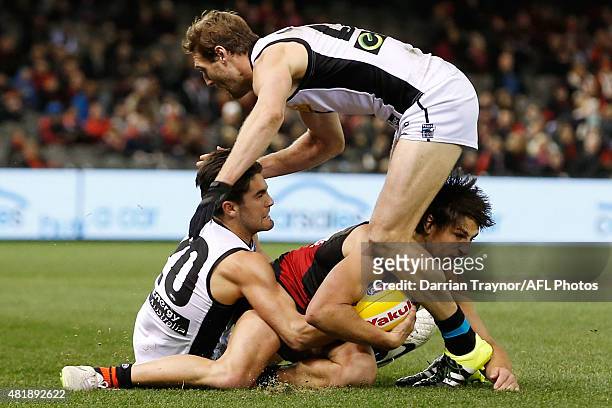 Mark Baguley of the Bombers wins the ball from Chad Wingard and Jay Schulz of the Power during the round 17 AFL match between the Essendon Bombers...