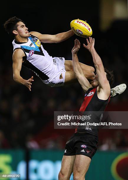 Chad Wingard of the Power leaps for a high mark attempt over Michael Hibberd of the Bombers during the round 17 AFL match between the Essendon...