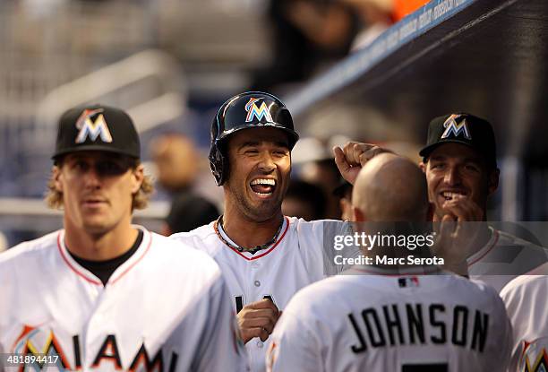 Garrett Jones of the Miami Marlins celebrates scoring a run with teammates against the Colorado Rockies during the third inning at the Marlins Park...