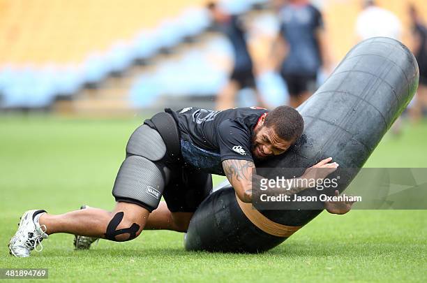Manu Vatuvei of the Warriors practices tackling on a large inner tube during a New Zealand Warriors NRL training session at Mt Smart Stadium on April...
