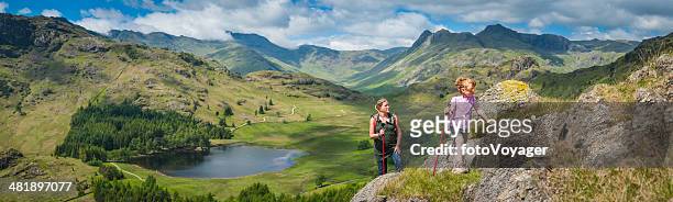 active mother and daughter hiking in idyllic mountain scenery panorama - lake district stock pictures, royalty-free photos & images